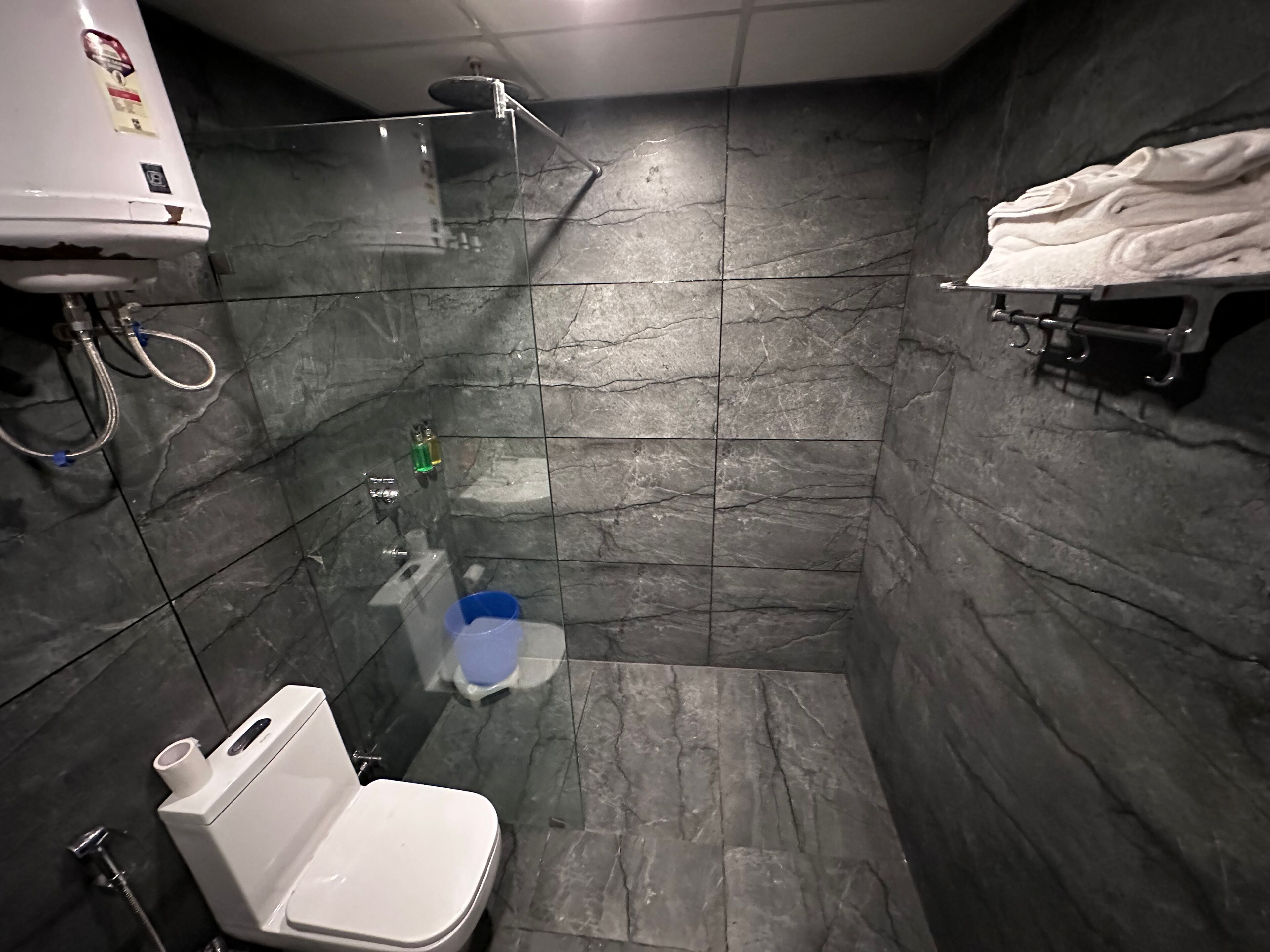 Un baño pequeño con inodoro, ducha y barra para toallas.
