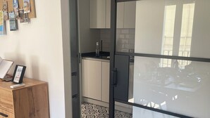 Eine moderne Küche mit weißen Schränken, einer schwarzen Arbeitsplatte und Fliesenboden mit Muster.