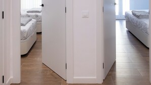 Ein modernes Schlafzimmer mit einem großen Bett, einem Nachttisch und einem Fenster mit Jalousien.