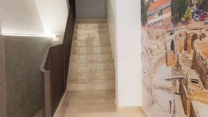 Eine modern gestaltete Treppe führt zu einem Raum mit einem Stadtbild-Mural.