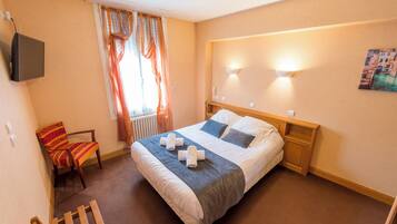 Une chambre d’hôtel avec un lit, une chaise, un radiateur et un tableau au mur.