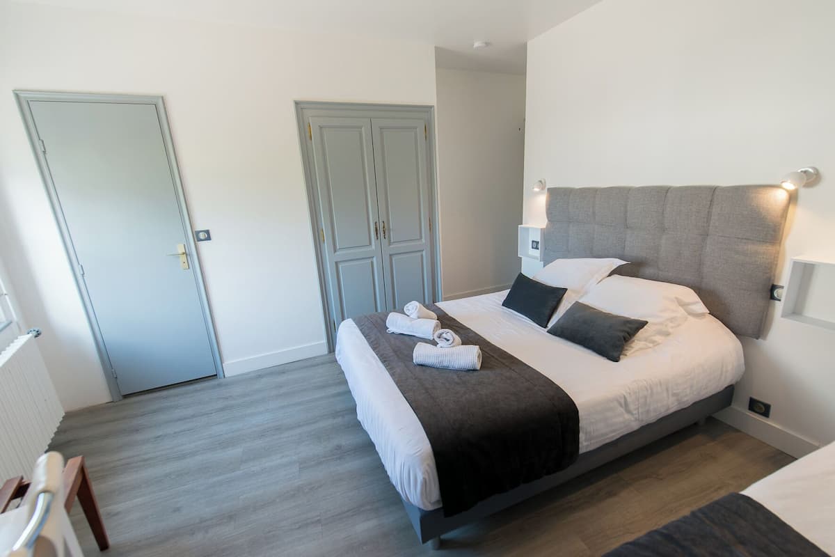 Quarto de hotel moderno com uma cama grande, um guarda-roupa e um abajur.
