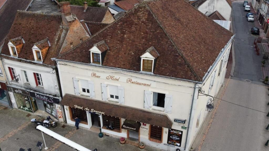 A building with a sign for a bar, hotel, and restaurant.