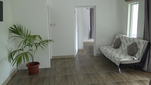 Habitación básica doble, 1 habitación | Zona de estar | Televisión LCD de 32 pulgadas con canales por cable