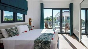 Una camera d'albergo con un letto, vista sull'esterno e un balcone.
