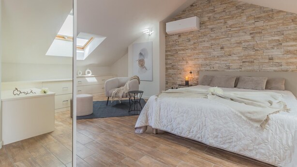 A bedroom with a stone wall, a bed, a chair, a desk, and a skylight. - Casa Mimosa in Lierna (Lierna)
