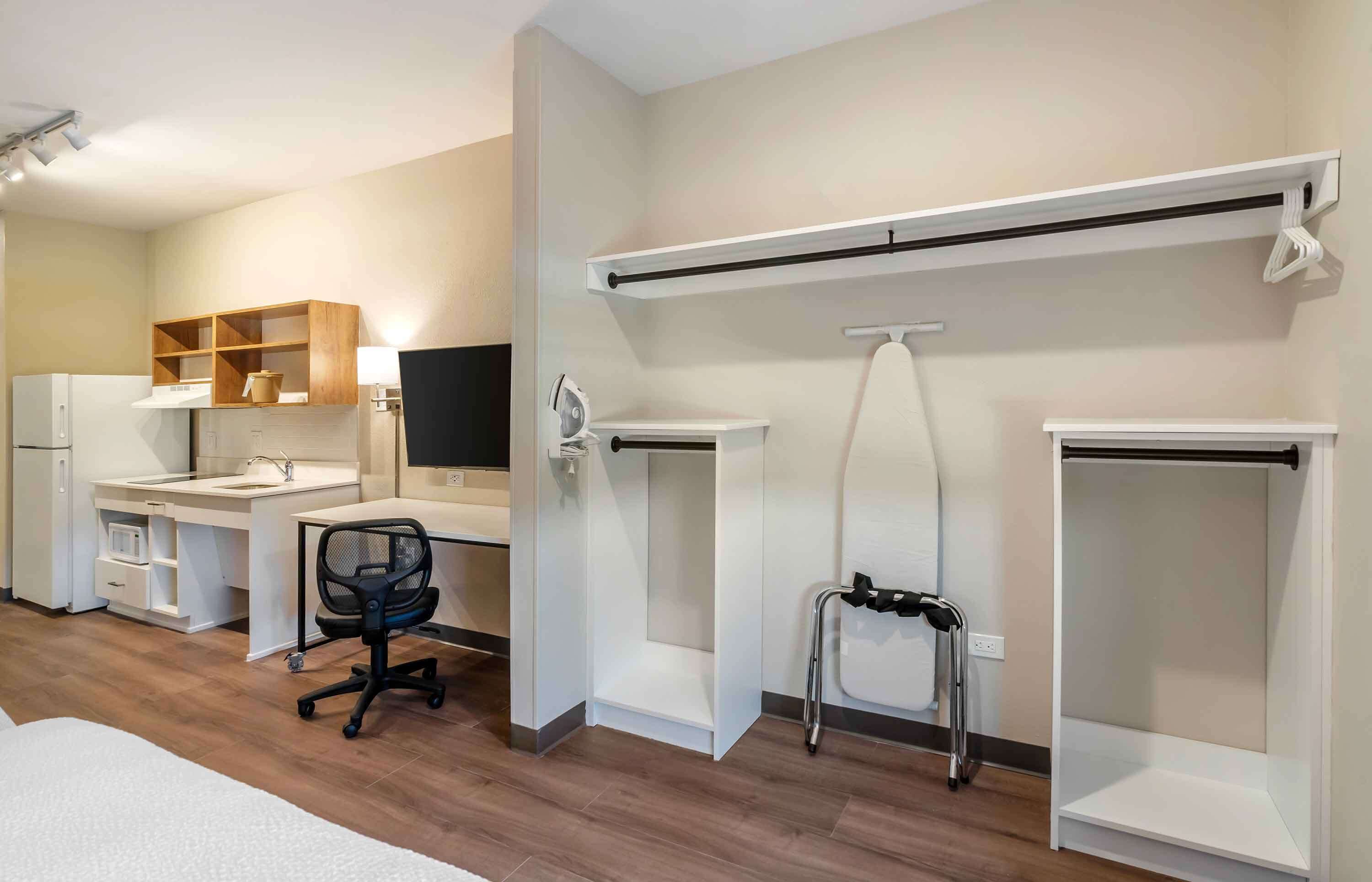 A modern room with a desk, chair, and built-in shelving.