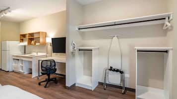 A modern room with a desk, chair, and built-in shelving.