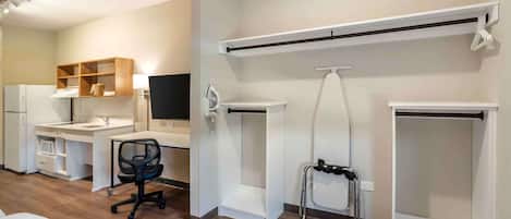 A modern room with a desk, chair, and built-in shelving.