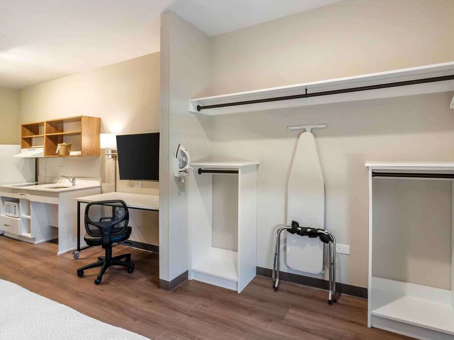A modern room with a desk, chair, and built-in shelving.