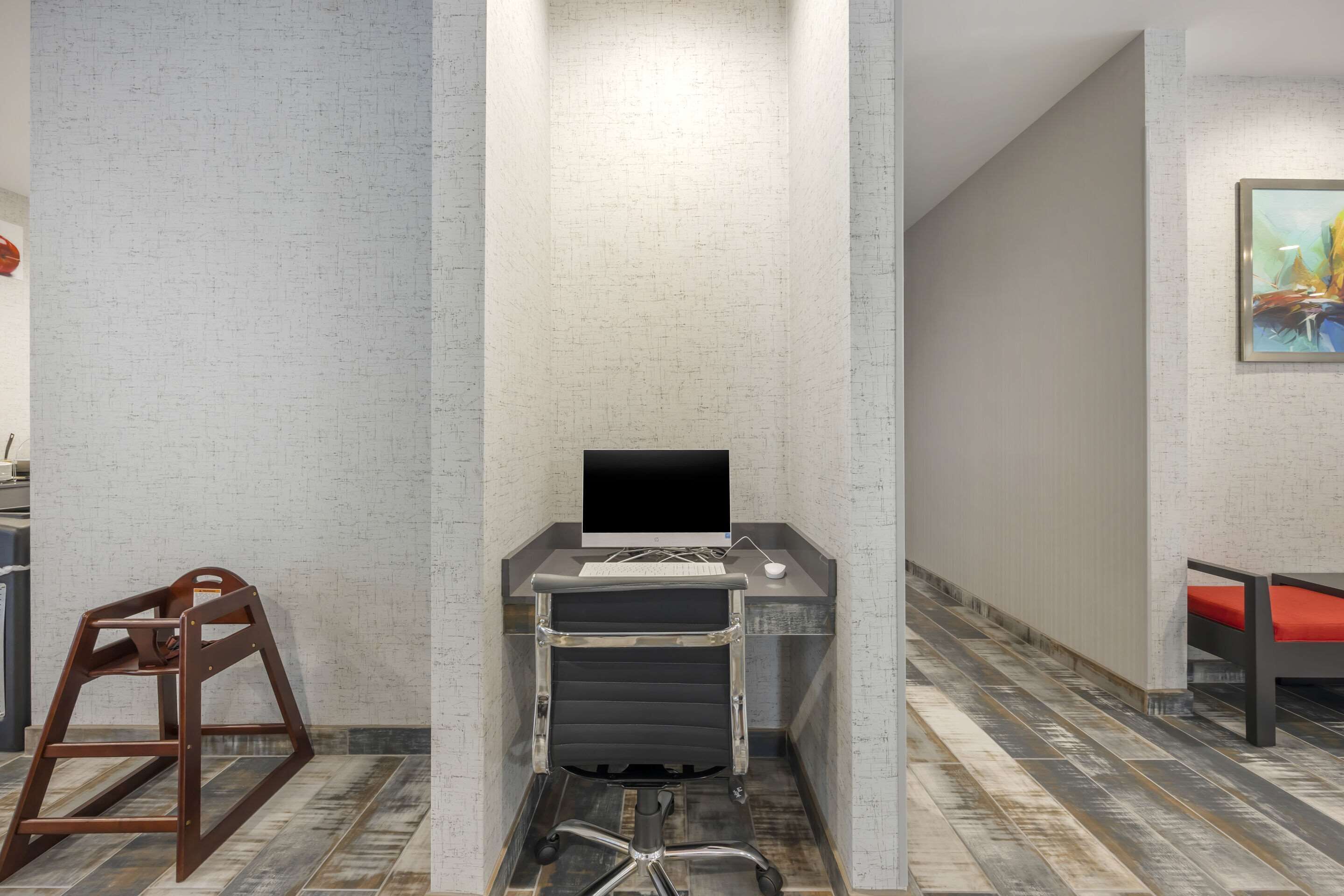 Un espacio de oficina moderno con un escritorio, una silla y una computadora.