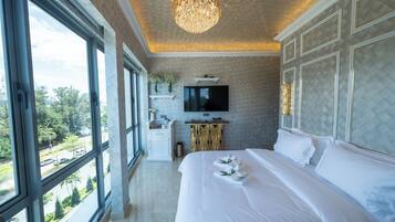 Een hotelkamer met een groot bed, een televisie, een houten kast en uitzicht.