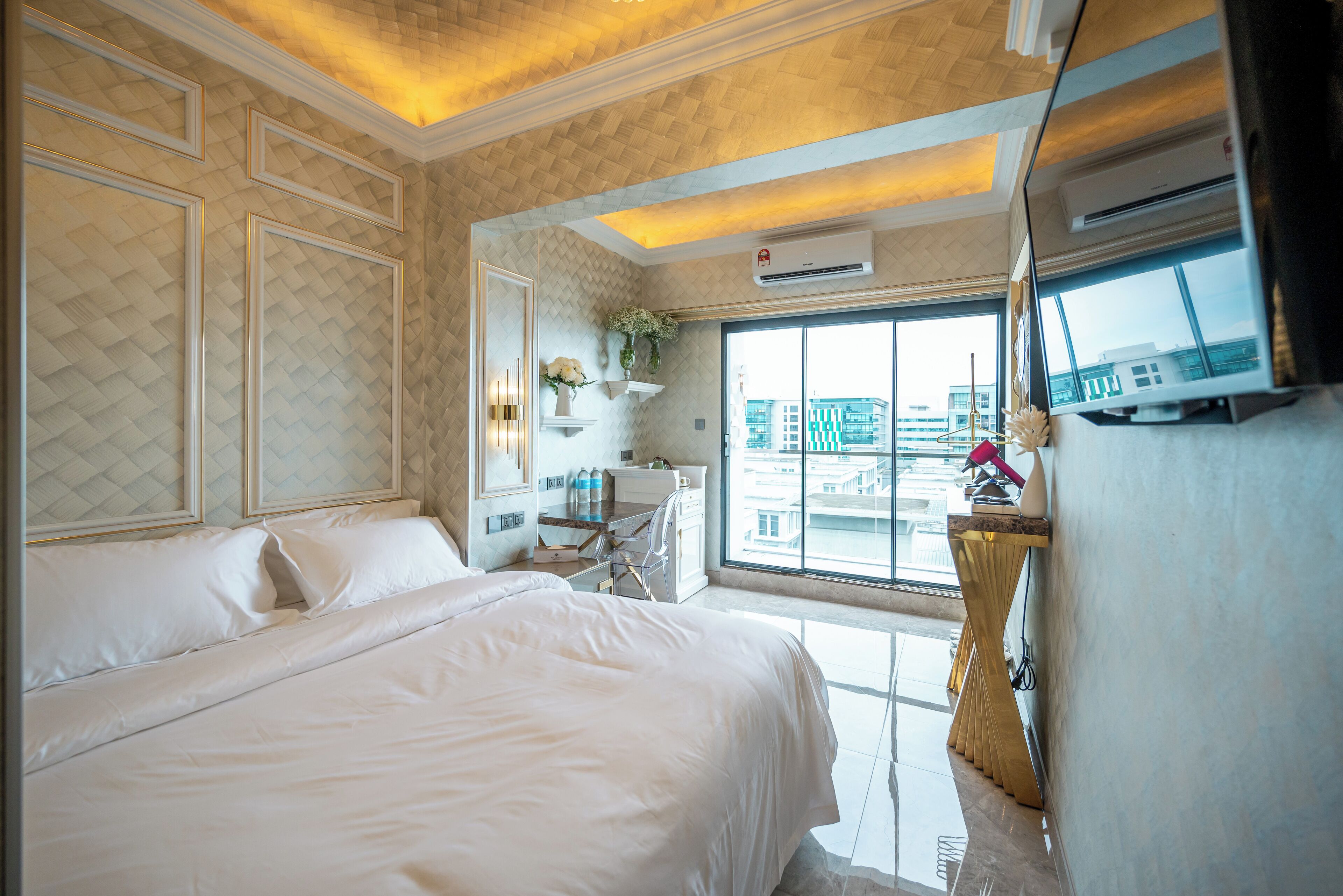 Hotelkamer met een groot bed, een bureau met stoel, een televisie en een raam met uitzicht over de stad.