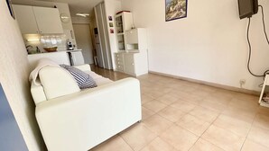Un espacio habitable compacto con cama, kitchenette y un pequeño comedor.