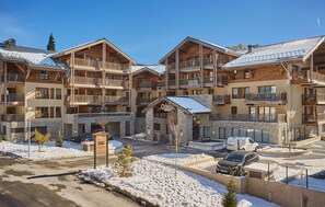 A multi-story hotel with balconies, stone facade, and snow-covered surroundings. - Résidence  Odalys Le Mont dAuron (Saint-Etienne-de-Tinee)