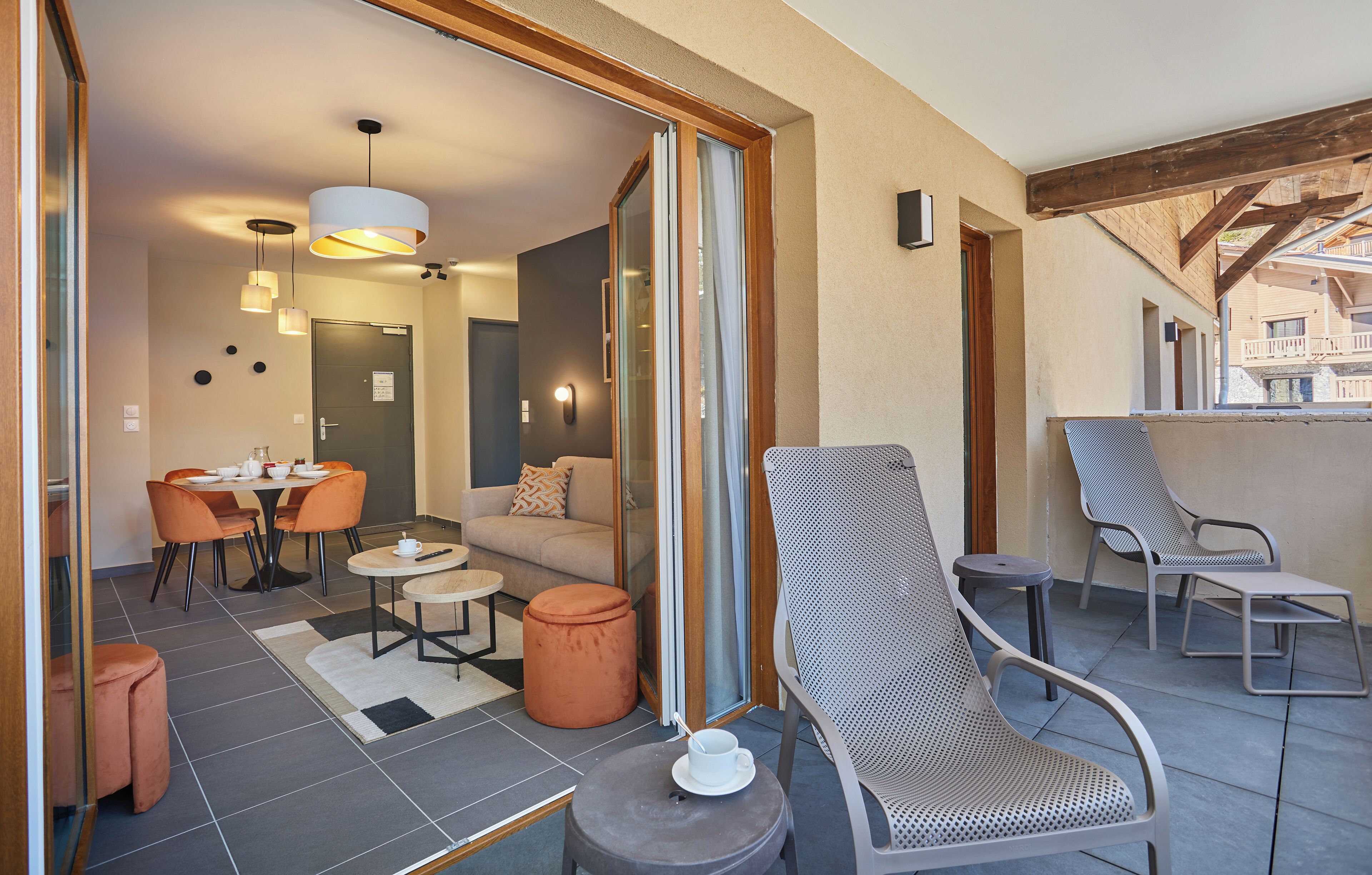 Un interior moderno con zona de comedor, un sofá y sillones.