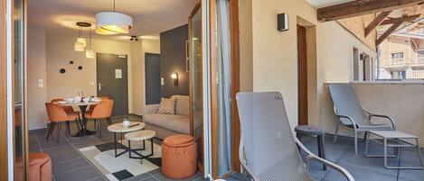 Un interior moderno con zona de comedor, un sofá y sillones.