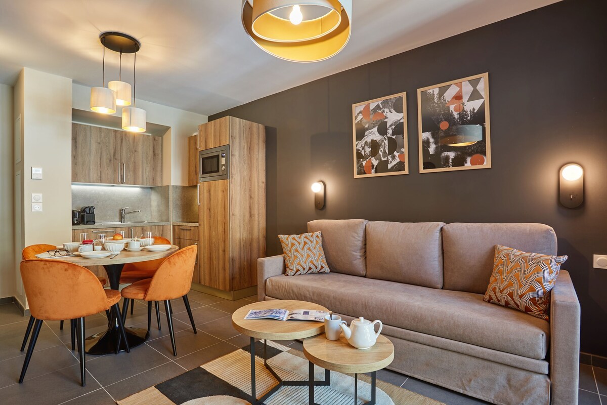 A modern living room with a sofa, coffee table, and dining area.