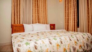 Ein Schlafzimmer mit Bett, Vorhängen und Nachttisch.