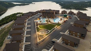 A hotel with a central courtyard, parking, and a view of a lake.