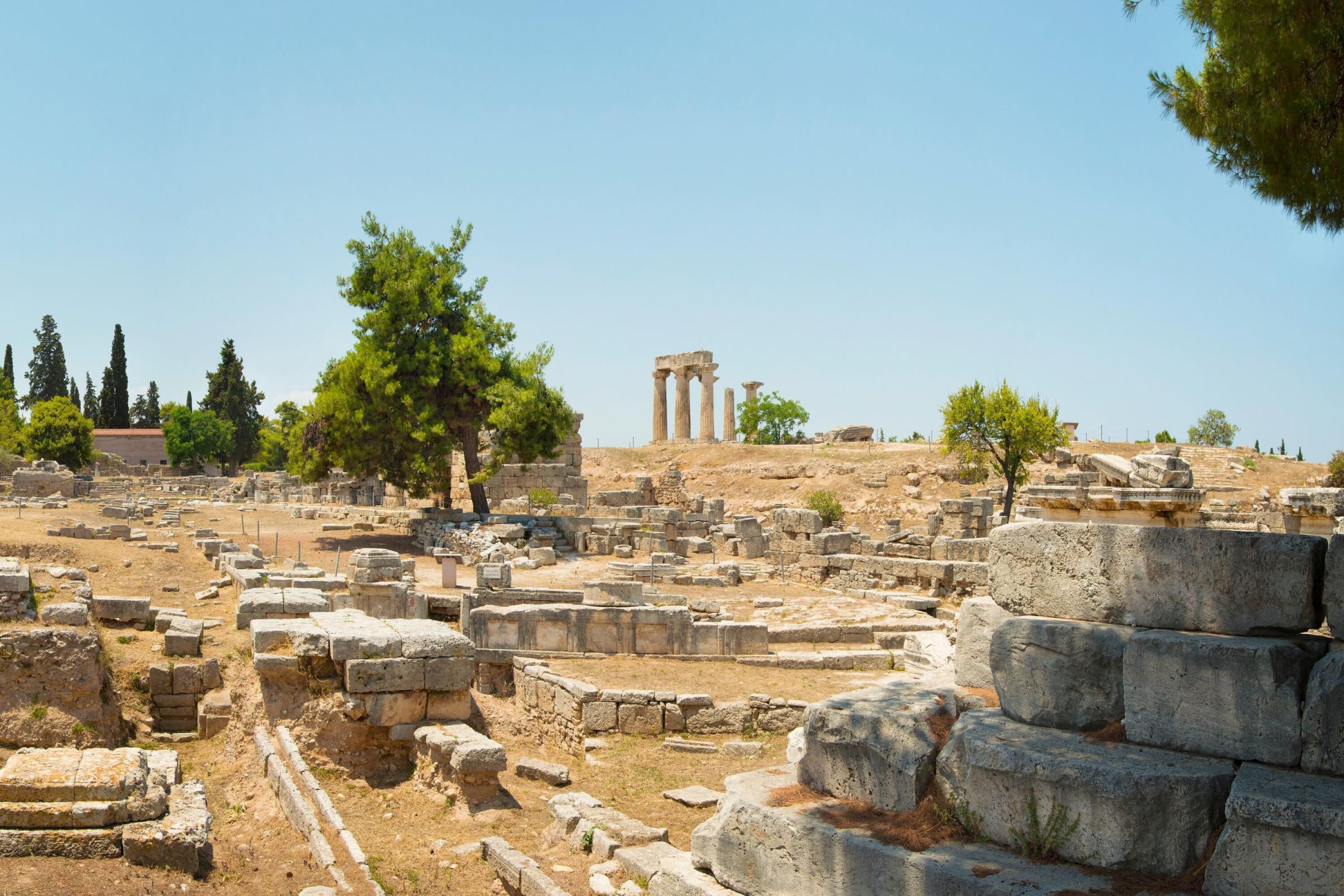 Rovine antiche con colonne in pietra e blocchi di pietra sparsi.
