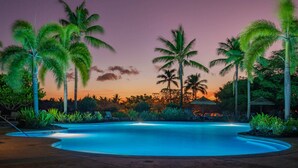 A swimming pool surrounded by palm trees and lounge chairs at dusk. - Luxury + Privacy ✨ Near Putting Green ⛳ Beach Club Access 🏖️ (Waimea)