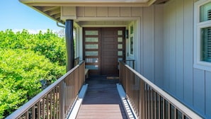 A wooden deck leading to a house with a brown door and a window with blinds. - Luxury + Privacy ✨ Near Putting Green ⛳ Beach Club Access 🏖️ (Waimea)