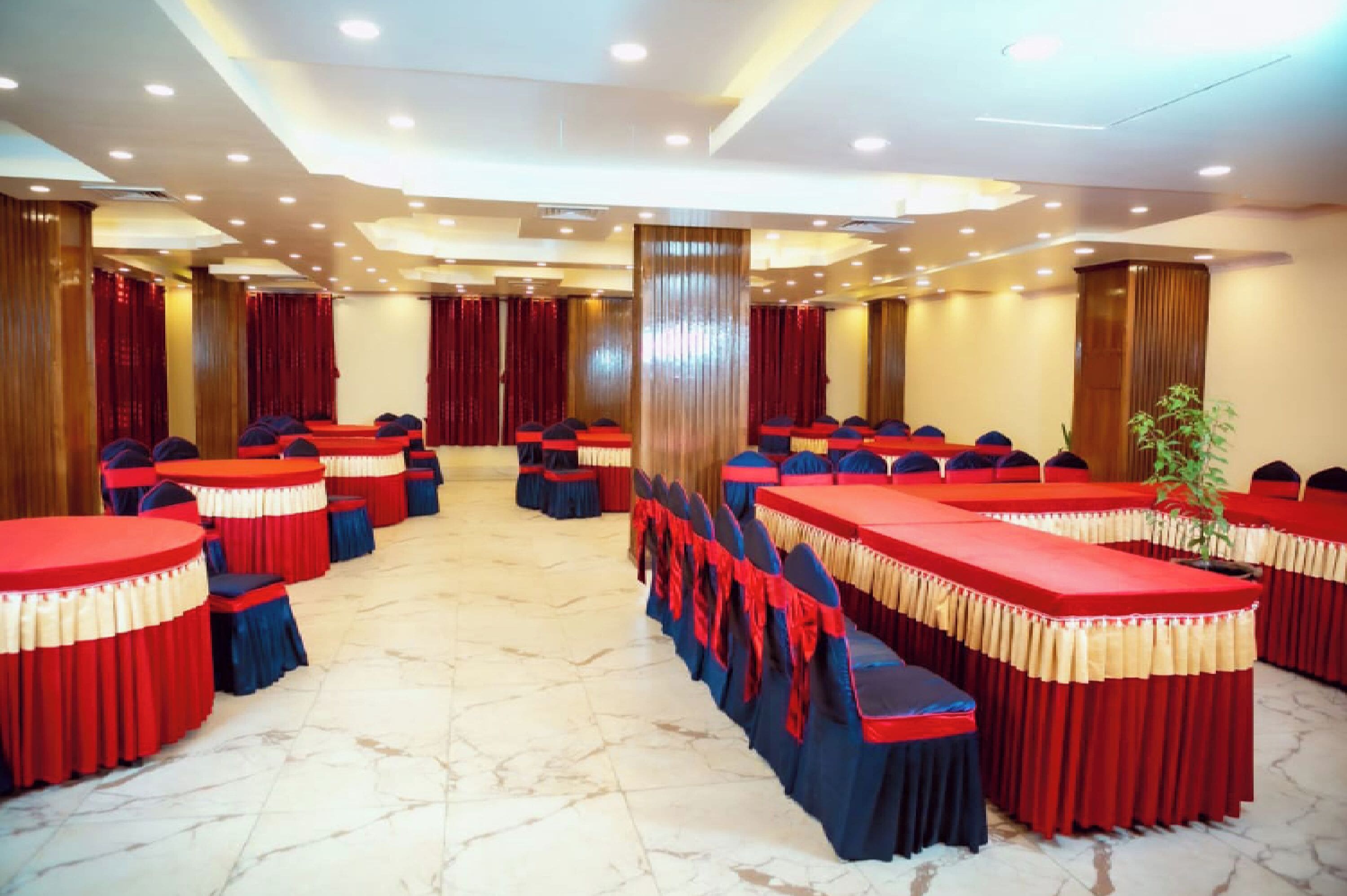 A conference room with multiple tables and chairs, arranged in rows.