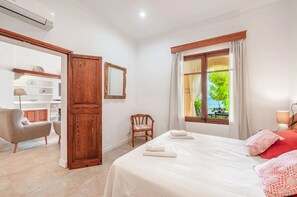 Une chambre d’hôtel avec un lit, une chaise, un bureau et une fenêtre donnant sur un paysage verdoyant.
