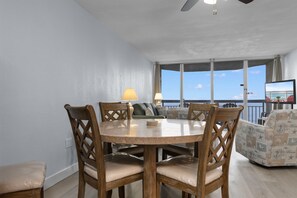 Un comedor con una mesa redonda y sillas, un sofá y una televisión.