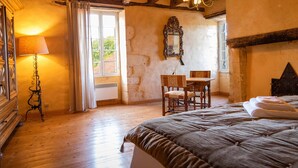 A bedroom with a wooden bed, a desk with a chair, a lamp, and a mirror on the wall.