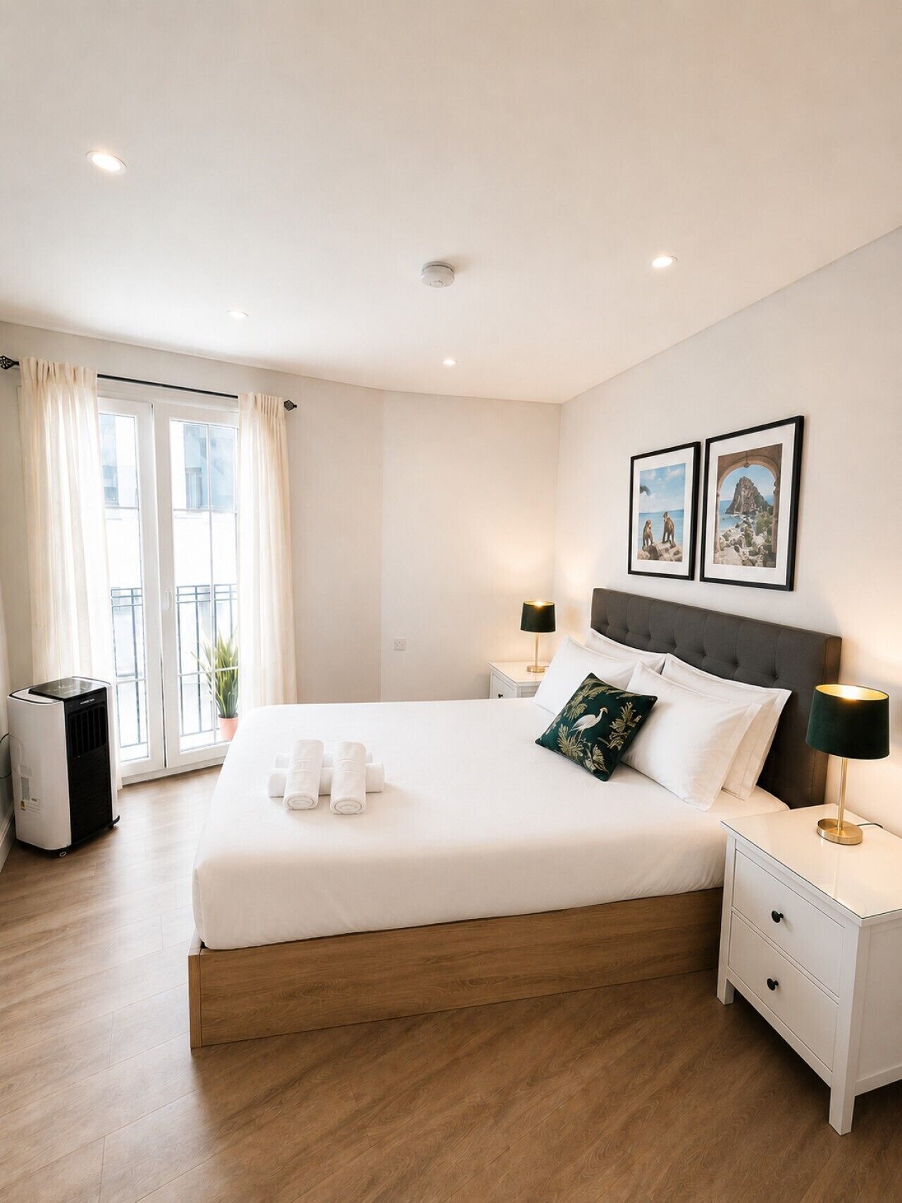 Een hotelkamer met een groot bed, nachtkastjes, een verwarming en een raam met gordijnen.