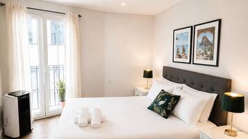 Een hotelkamer met een groot bed, nachtkastjes, een verwarming en een raam met gordijnen.