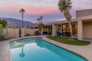 Relax by the pool surrounded by palm trees and a stunning mountain view.