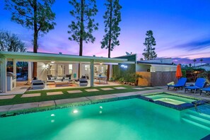 Uma casa moderna com piscina, área de estar externa e um pátio.