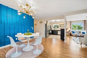 Relax in a stylish living space with a vibrant accent wall, dining area, and modern kitchen.