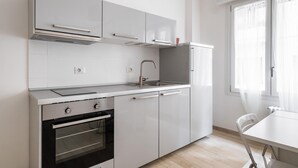 A modern kitchen with white cabinets, a stainless steel sink, and an oven. - Al Mercato Delle Erbe by Wonderful Italy (Bologna)