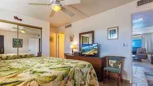 A hotel room with a bed, a television, a desk, and a chair. - Kihei Beach #507: Your Front-Row Seat to Paradise (Kihei, Maui)