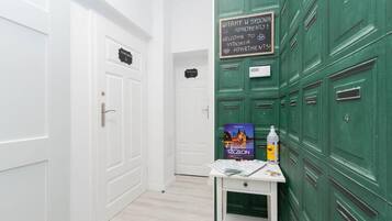 A hallway with green lockers, a white door, and a welcome sign for apartment 51.