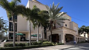 A modern building with a library named 'Warren Library' and outdoor seating. - Cozy & Welcoming Home in Antique Row WPB (West Palm Beach)