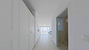 A long, narrow hallway with white walls and wooden flooring. - Sea View Studio 1 in San Agustin (San Agustin)