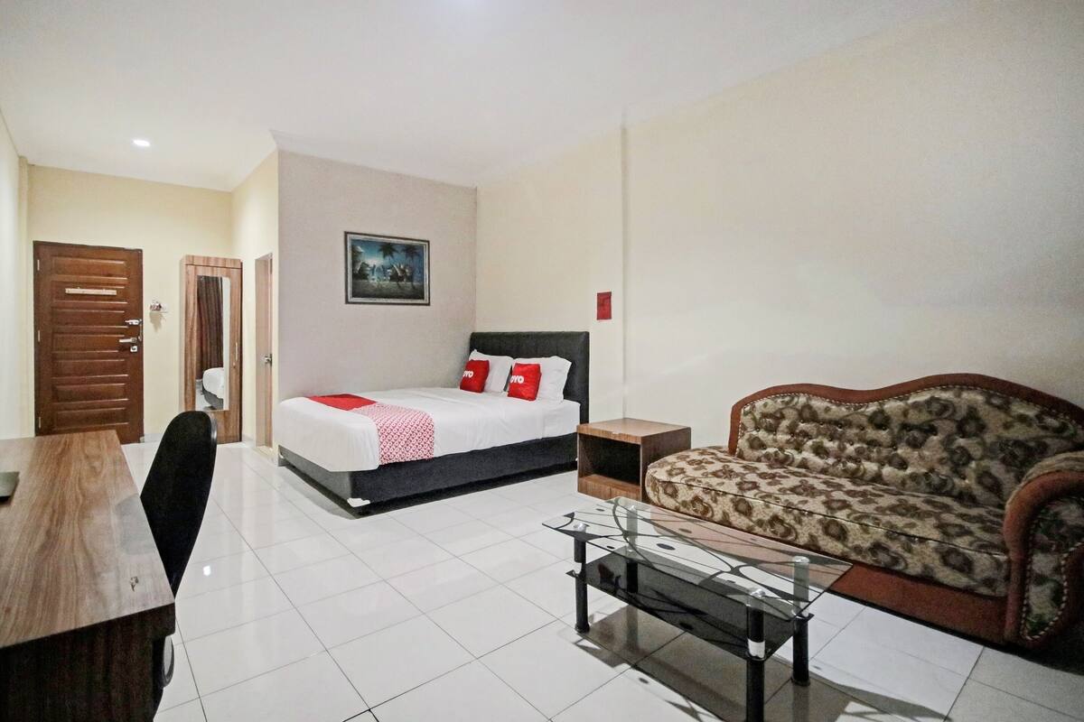 Una habitación de hotel con una cama, un sofá, un escritorio y una silla.