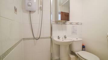 Un baño con ducha, lavabo e inodoro.