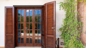 Una puerta de madera con paneles de vidrio y un escalón que lleva a ella.