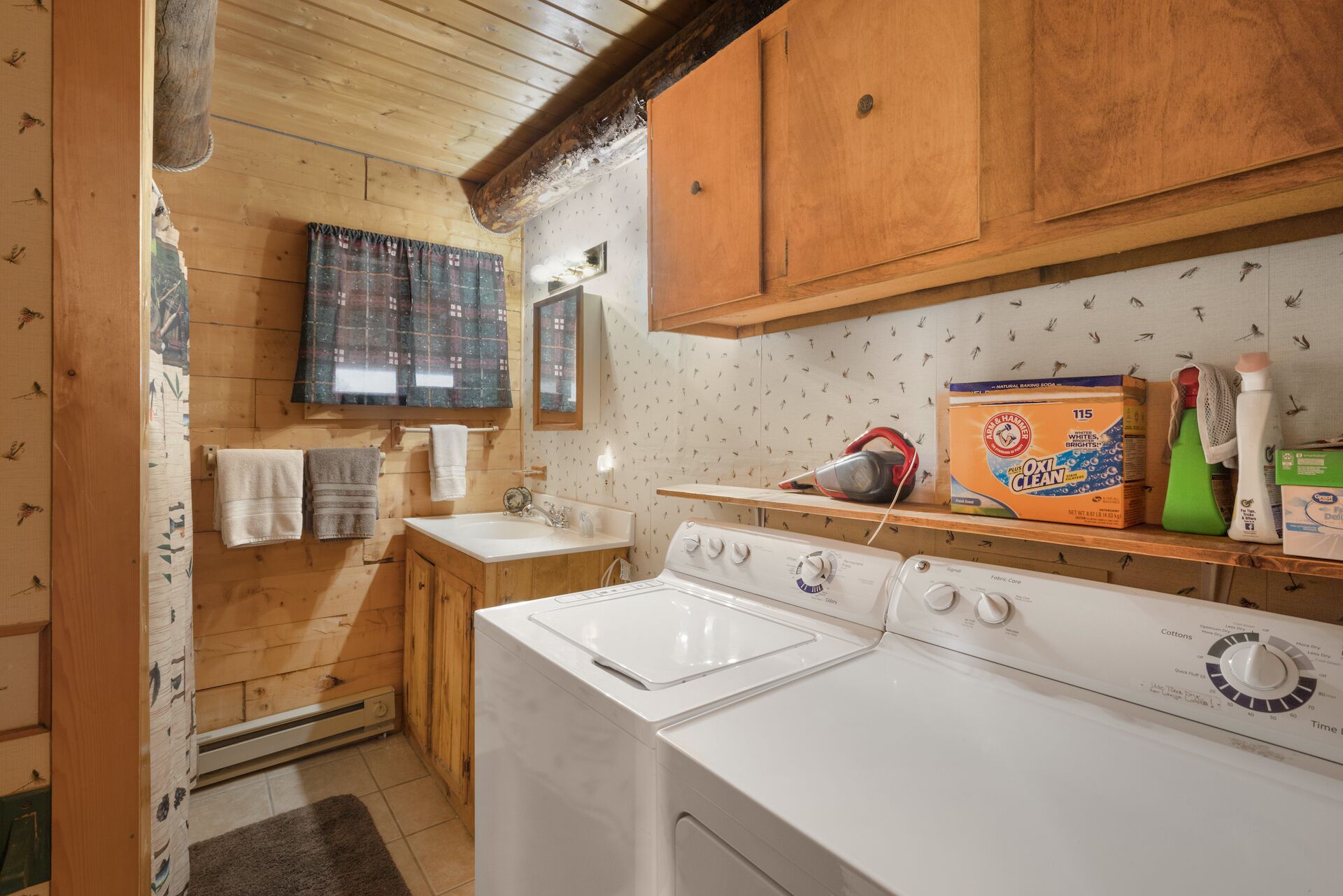 A compact kitchen with wooden cabinets, a built-in oven, and a washing machine.