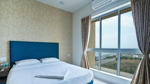 Une chambre d’hôtel avec un grand lit, une vue sur un pont et une fenêtre avec des rideaux.