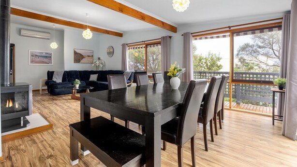 Een moderne woonkamer met een open haard, een eettafel en een bank.
