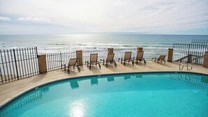 A pool with a view of the ocean, surrounded by a fence and lounge chairs. - 10% OFF last minute stays - Oceanfront 1 bedroom, Pool, Spa, Beach Access (Solana Beach)