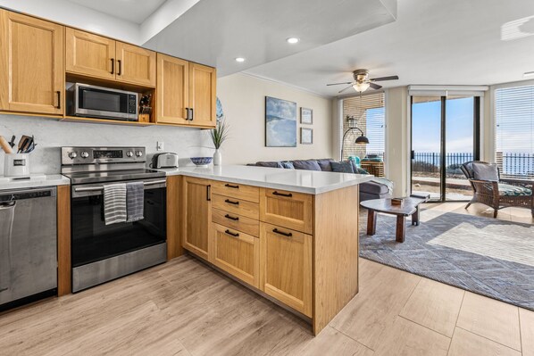 A modern kitchen with wooden cabinets, stainless steel appliances, and a large island. - 10% OFF last minute stays - Oceanfront 1 bedroom, Pool, Spa, Beach Access (Solana Beach)