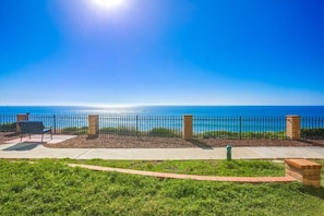 Enjoy ocean views from a serene outdoor space with a paved area, benches, and a decorative brick feature.